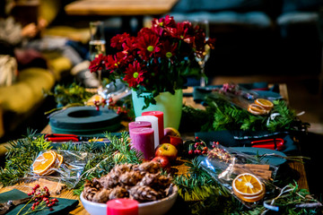 candles on Table with accessories for making by hand a unique magic Christmas wreath, background