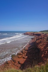Prince Edward Island, Canada: A red sandstone beach under a clear blue sky on the north shore of...