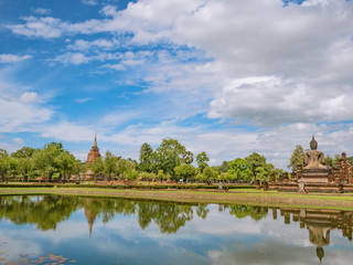 Ruin of Pagoda and statue in Wat mahathat Temple Area and reflection in the water At sukhothai historical park,Sukhothai city Thailand