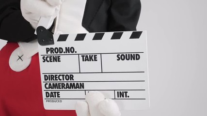 Hands in white gloves with movie production clapper board, on white background - Powered by Adobe