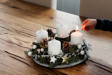 Close up of lighting the first candle on Advent Wreath on the first Sunday in December. Celebrating...