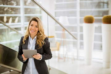 Young businesswoman with tablet in the modern office