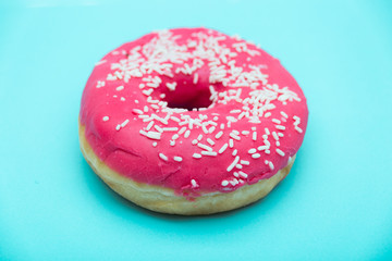 pink donut with sprinkles isolated on blue background