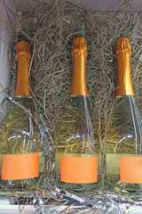 three bottles of champagne lying on straw