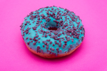 blue donut with sprinkles isolated on pink background