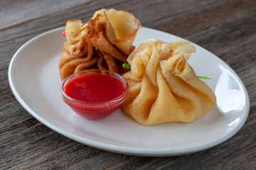 Vegetarian breakfast: pancakes stuffed with cottage cheese with strawberry jam