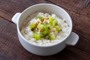 Vegetarian breakfast: Rice milk porridge with banana, pear and kiwi slices