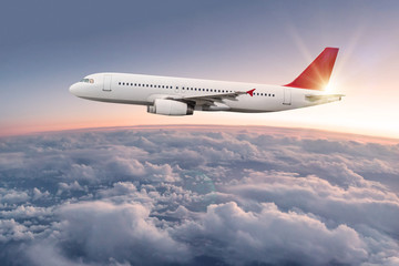 Commercial airplane flying above dramatic clouds.