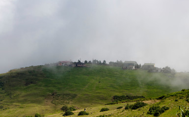Fototapeta na wymiar View of high plateau village in fog creating beautiful nature scene. The image is captured in Trabzon/Rize area of Black Sea region located at northeast of Turkey.