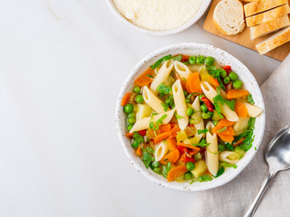 Minestrone soup, Italian cuisine. Vegetarian soup with vegetables, Penne paste, cheese. White table, top view, copy space