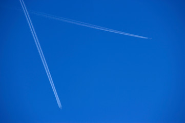 TWO  JET AIRCRAFT WITH EXHAUST VAPOUR TRAILS IN CLEAR BLUE SKY