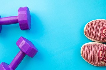 Fitness equipment dumbbells on color background. Flat lay.