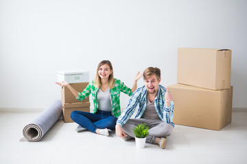 Relocation, new home and real estate concept - Young couple upacking in their new flat together