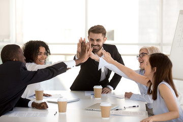Happy motivated diverse business team people giving high five together celebrating goal...