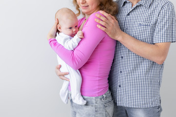 Family, childhood and parenthood concept - Close up of Father, mother holding cute baby over white background