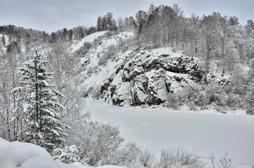 Beautiful winter landscape of frozen mountain river with rocky shores