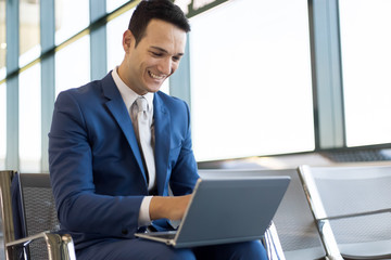 Young businessman working with his laptop in an airport