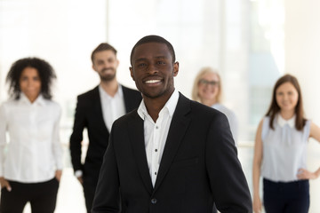 Portrait of smiling confident african american corporate leader or company ceo in suit posing with...