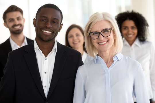 Diverse old and young professional business coaches or corporate leaders with team people portrait, smiling multiracial executive partners, african caucasian company staff group looking at camera