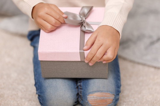 Child hands holding beautiful pink gift box