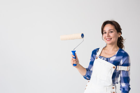 Repair, Renovation, New Home And People Concept - Young Woman Doing Redecoration And Show Us Thumbs Up Over White Wall With Copy Space