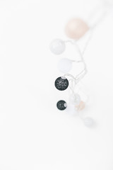 White, black, gold, silver christmas lights on white textured background.
