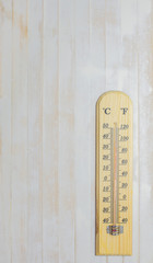 The thermometer on white wooden floor with space.