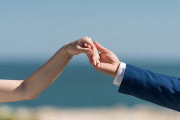 Bride and groom holding their hands - detail. Selective focus, copy space