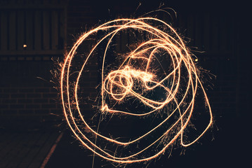 Large bright Circles drawn out by a young girl using a sparkler on bonfire day in the UK 2018