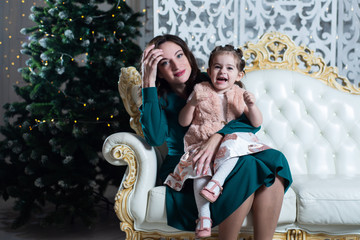 Merry Christmas and happy holidays. Mother and daughter near the Christmas tree