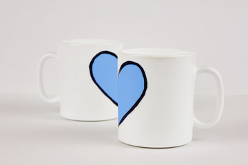 Blue heart and two cups on white background. Valentine's day, love, couple, wedding concept