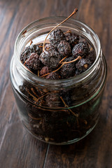 Jar of Dried Cherry Ready to Eat on Dark Wooden Surface.