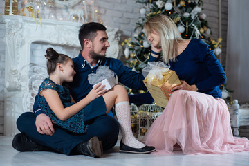 Obraz na płótnie Canvas Christmas photo of happy family with gift boxes on background of decorated Christmas tree. Family celebrates New year