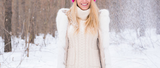 Fun, winter and people concept - Close up of young woman dressed in coat throwing snow.