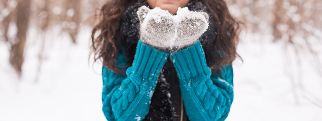 Close up of christmas Girl. Winter young woman blowing snow in winter nature