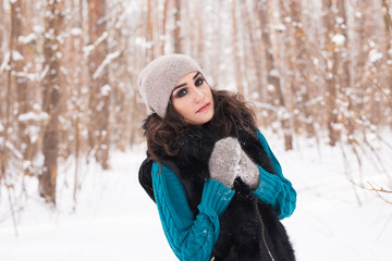 Beautiful young woman walking in the winter snowy nature