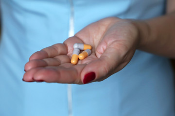 Pills in female palm close-up, woman doctor holding capsules. Concept of medicine, drugs, antibiotics, medical prescription