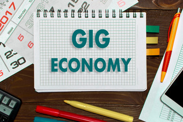 Notebook with a notes gig economy  on the office table with tools.