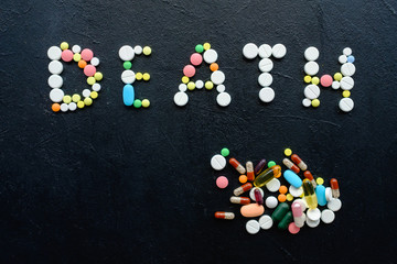 pills overdose. word death made of drugs on black background. antidepressant or painkillers...