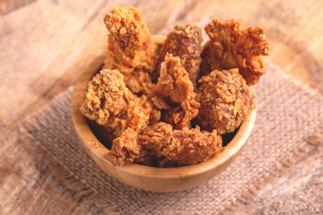 Delicious breaded chicken nuggets in wooden bowl on burlap napkin