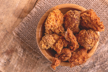 Delicious breaded chicken nuggets in wooden bowl on burlap napkin