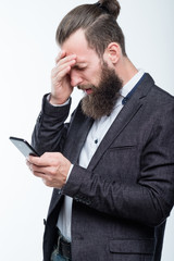 man grasping head and holding phone. failure and emotional reaction to bad news.