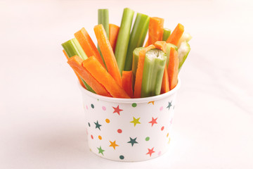 Fresh carrots and celery sticks in paper cup