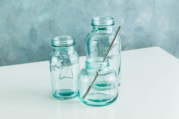 empty glass recycled bottles for breakfast, fresh juice and other kitchen needs. glassware on white table and blue background