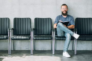 man sitting in the row of empty chairs. interview or job hiring concept.