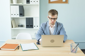 Business, technologies and people concept - Handsome man working in office on laptop