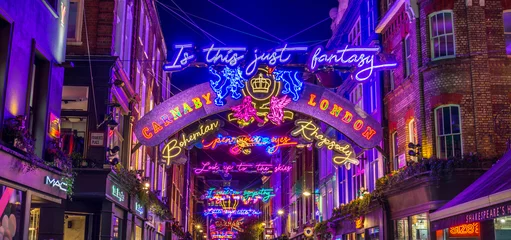 Zelfklevend Fotobehang Licht tijdens de kerstperiode Carnaby Street in Londen op. Er zijn grote aantallen mensen te zien. © offcaania