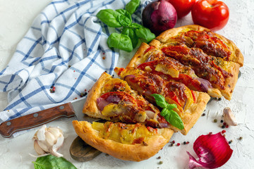 Vegetable pie with potatoes, onions and tomato.