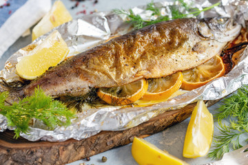 Baked lake trout with lemon slices.