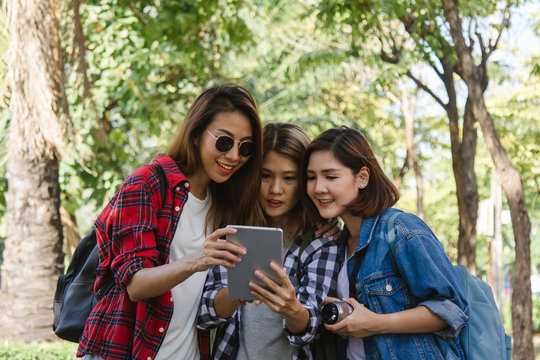 Group of Asian women using camera to make photo while traveling at park in urban city in Bangkok, Thailand. Lifestyle beautiful friends tourist travel holiday in Thailand concept.